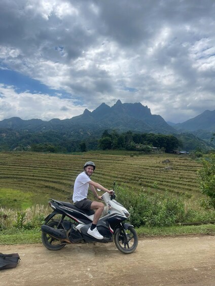 A person on a motorcycle with a mountainous landscape in the background. 3