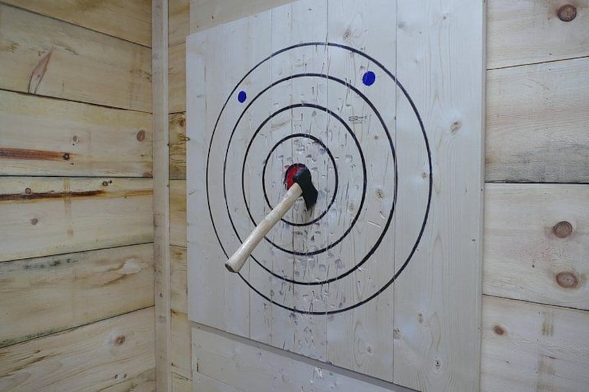 A wooden wall with a target board featuring concentric circles and a dartboard. 4