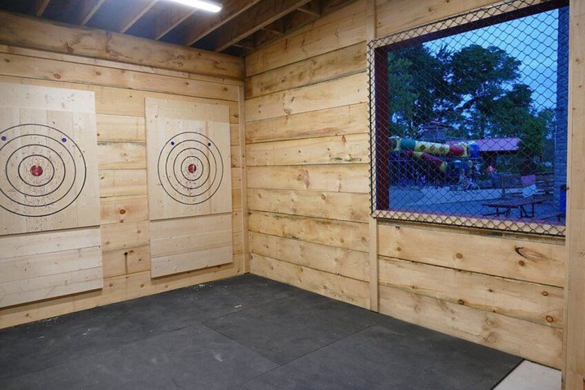 An indoor archery range with wooden walls and targets. 2