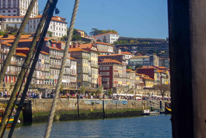 Eine Stadt am Flussufer mit bunten Häusern und einer Brücke im Hintergrund. 3