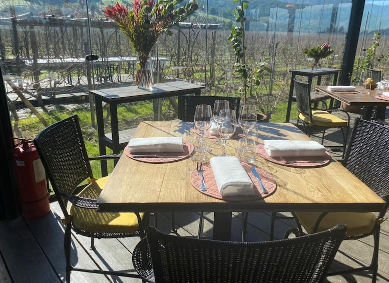A dining table set outdoors with chairs, a vase of flowers, and a fire extinguisher. 5