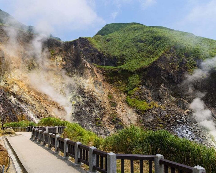 A volcanic landscape with a path and railing. 3