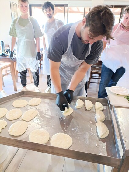 A person preparing dough on a flat surface. 5