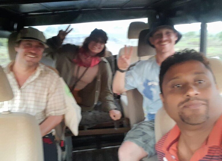 Four people in a vehicle, two in the front seats and two in the back. 4