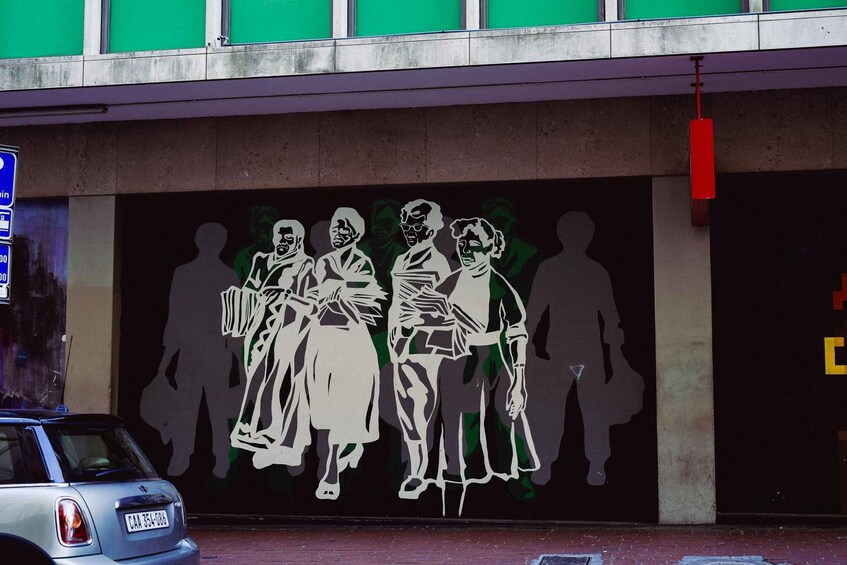 A mural of silhouetted figures on a building wall. 4