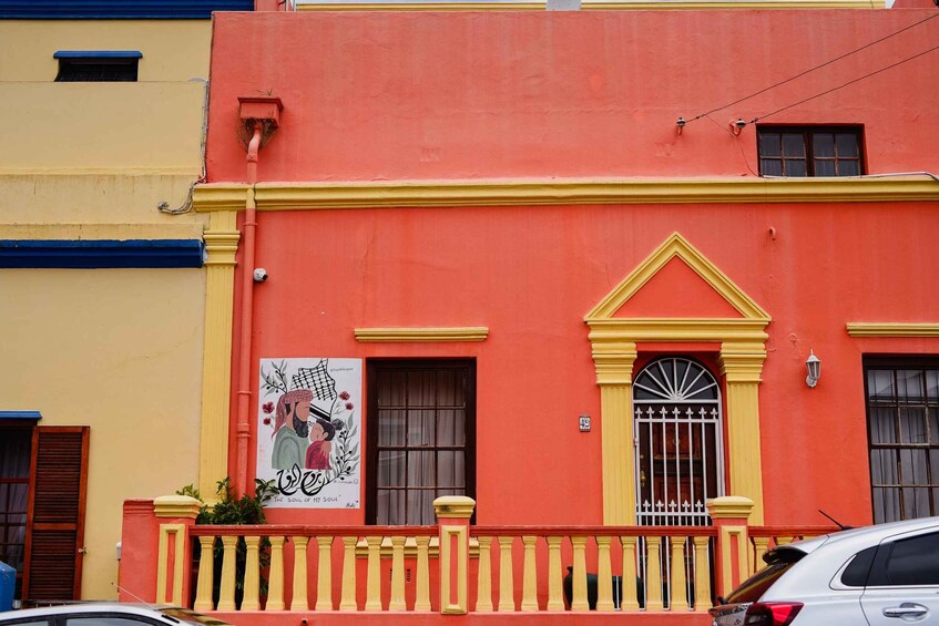 A colorful building with a red facade, yellow trim, and a balcony with a railing. 5
