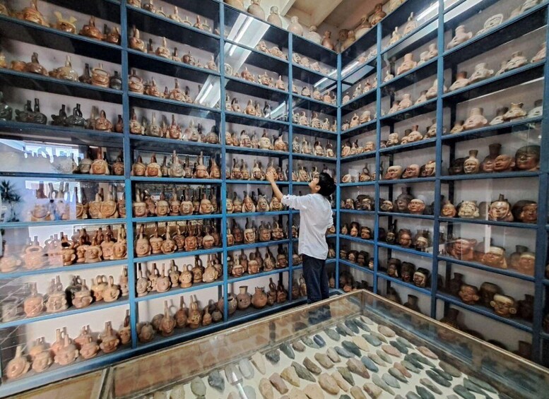 A person examining pottery in a museum. 5