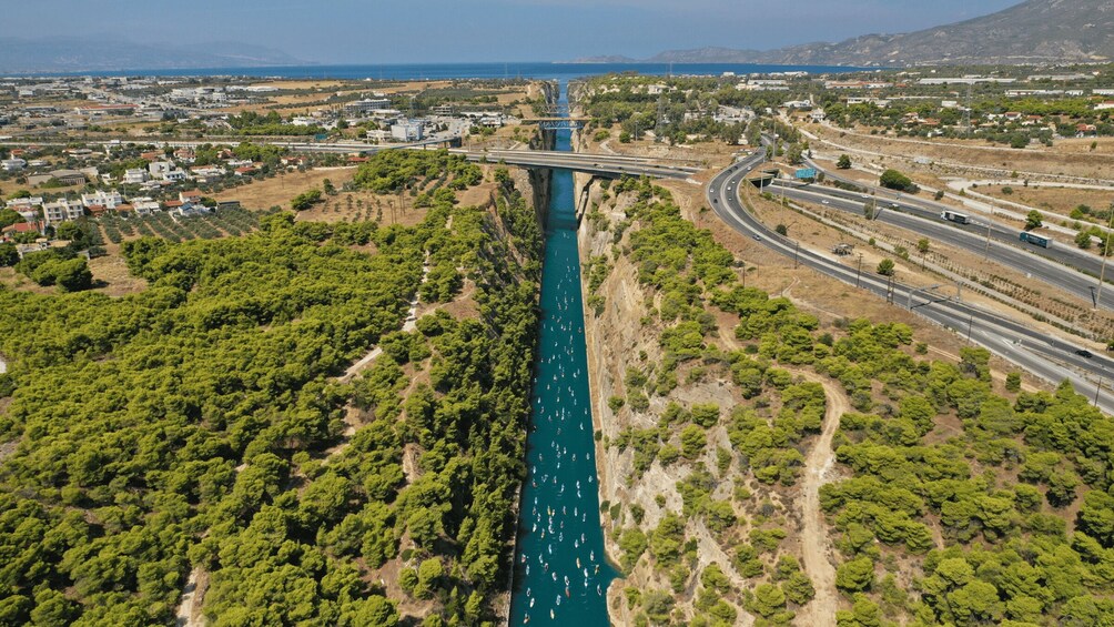 A river with boats, a bridge, and surrounding greenery. 2