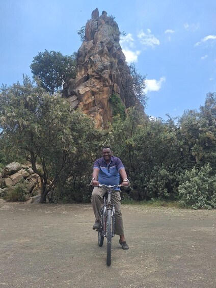 A person riding a bicycle in front of a rocky mountain. 5