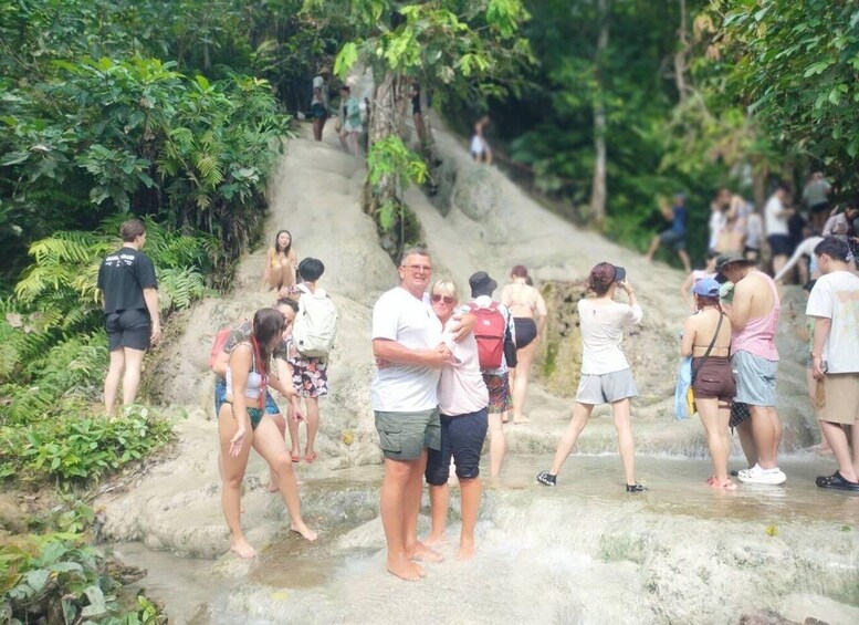 A group of people walking on a stone path surrounded by lush greenery. 3