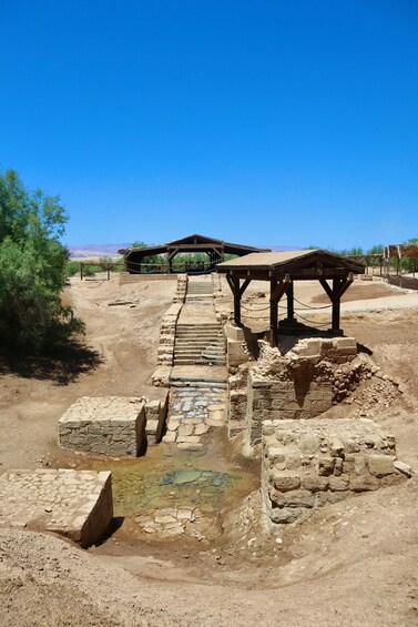 Ancient ruins with stone structures and a wooden shelter. 5