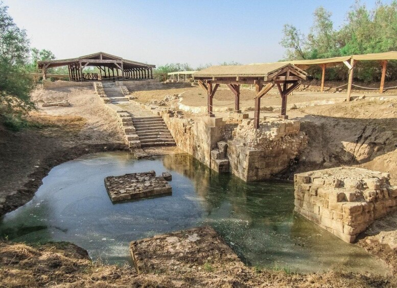 An archaeological site with stone structures and a water channel. 1