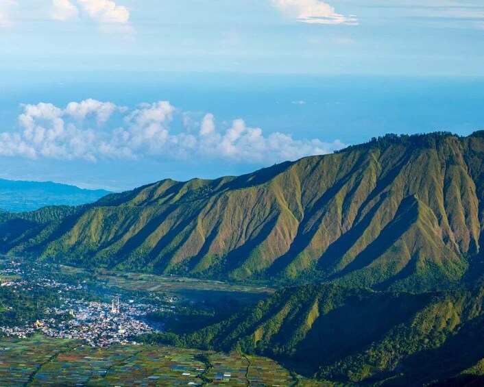 A mountainous landscape with a town nestled in the valley. 1