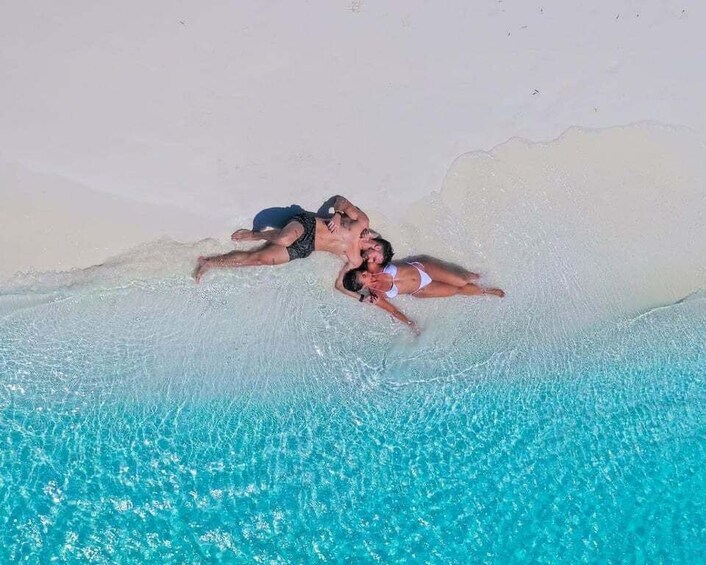 Dos personas descansando en una playa cerca de una piscina. 1