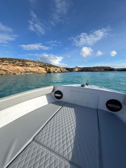 A boat's interior with a view of calm waters and rocky cliffs. 3