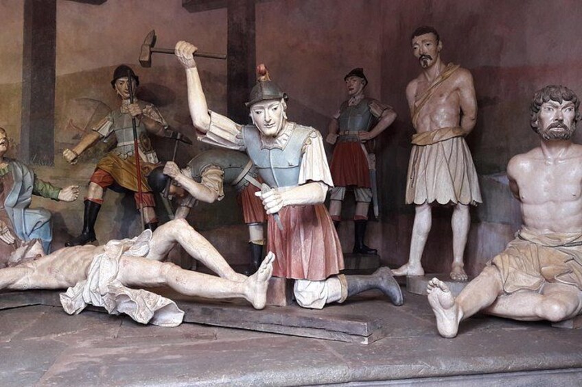 A historical scene with figures in armor and a fallen person on a platform. 2