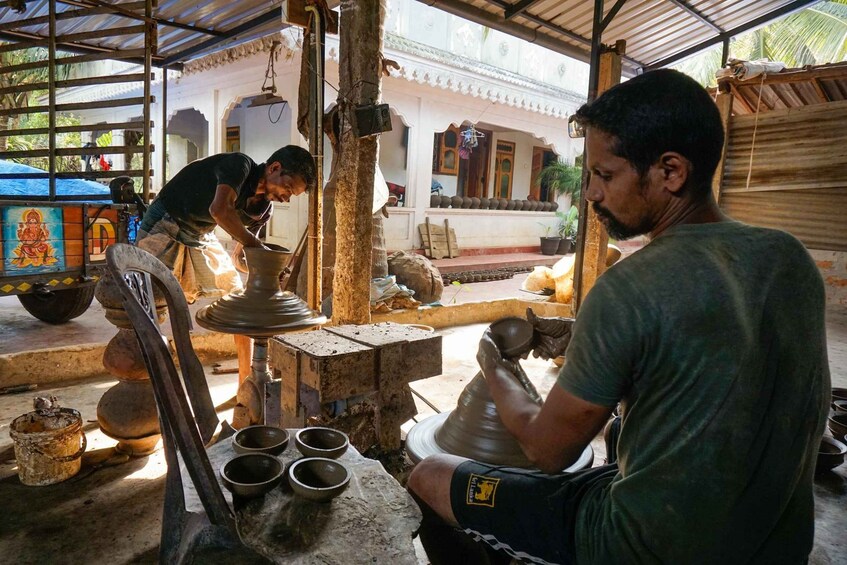 A pottery workshop with a potter shaping a clay pot on a wheel. 1