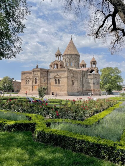 A historic church with multiple spires and a courtyard with manicured gardens. 3