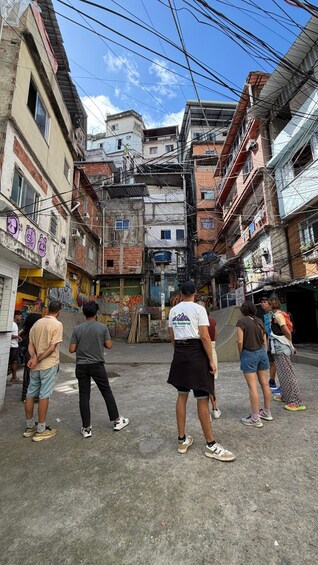 A narrow street with buildings on both sides, some with visible wear and graffiti. 1