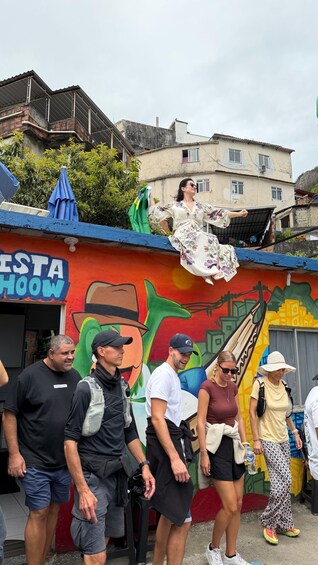 A group of people walking past a colorful mural with a 'FESTA SHOW' sign. 5