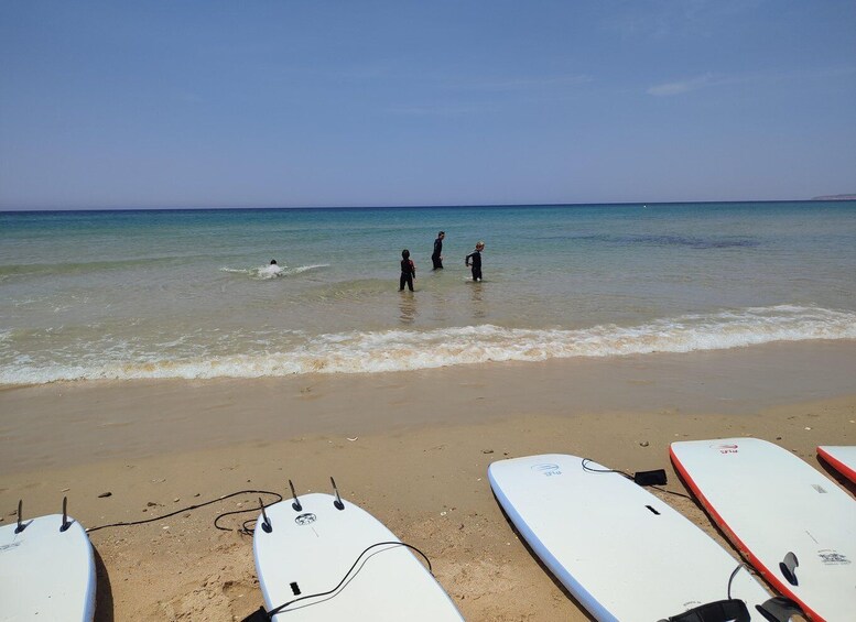 A beach with surfers and surfboards. 3