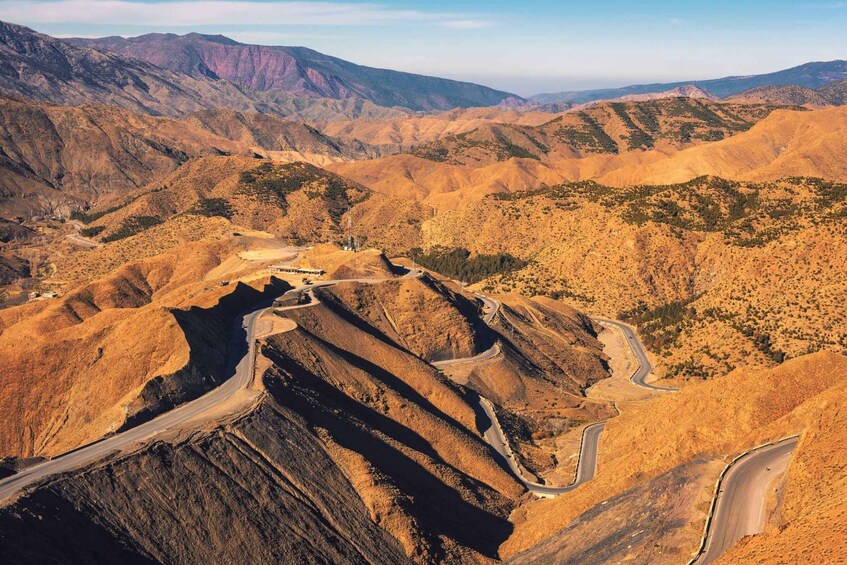 A winding road through a mountainous landscape with rocky terrain and sparse vegetation. 4