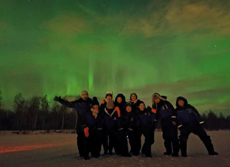 A group of people posing under the Northern Lights. 3