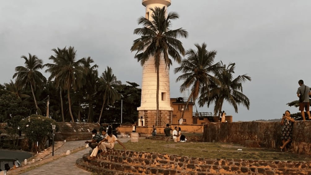 A lighthouse with palm trees in the background. 1