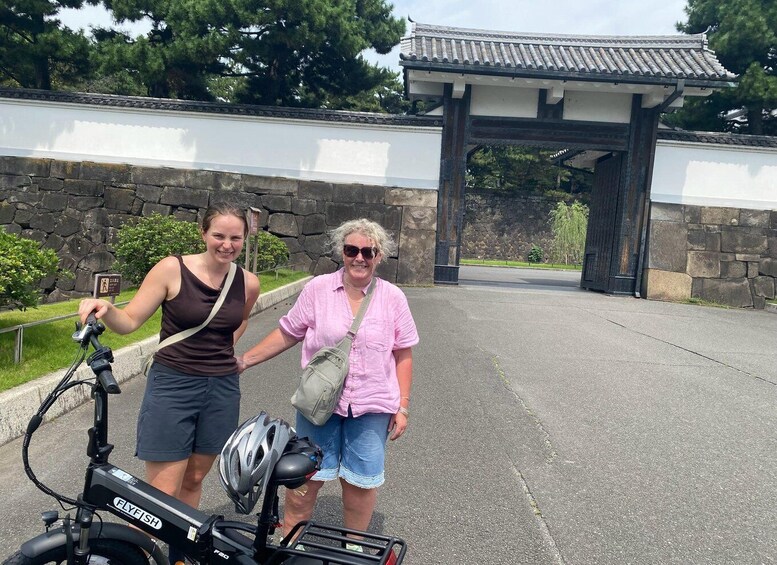 Two people standing next to a bicycle with a helmet on the seat. 4