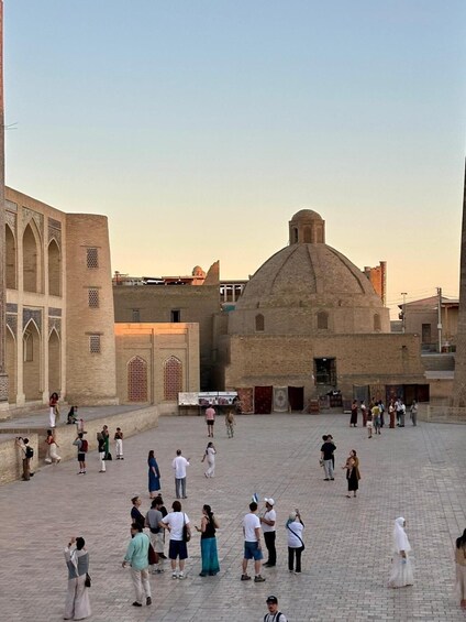 A historical square with a prominent dome and arched structures. 2