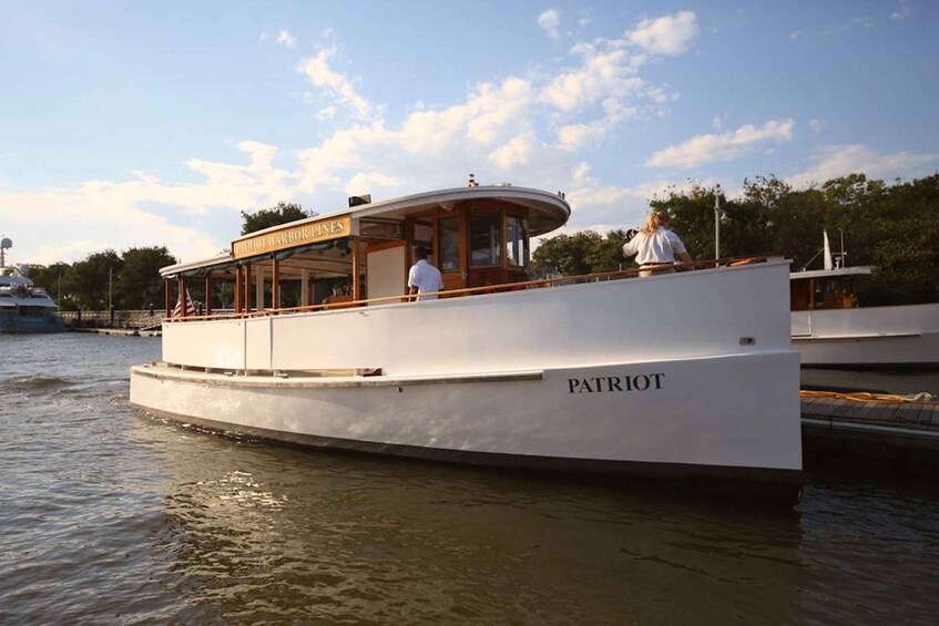 A white boat named 'Patriot' docked at a pier with a covered area labeled 'Pittsburg Harbor'. 1