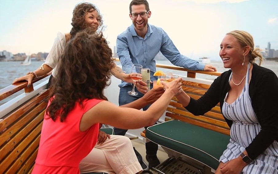 A group of people toasting on a boat with drinks. 3