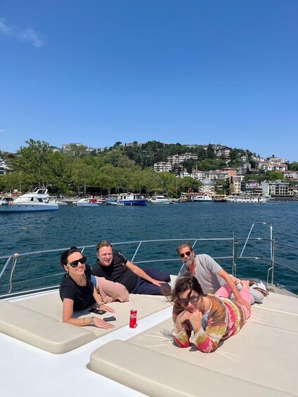 A group of people on a boat with a cityscape and hills in the background. 2