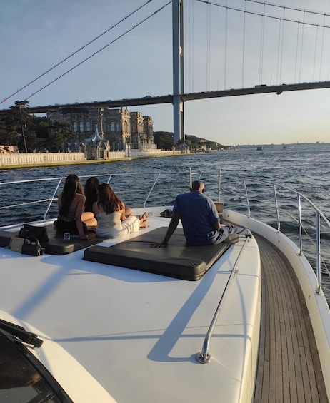 A boat with people relaxing on the deck, a bridge in the background, and a waterfront with buildings. 4