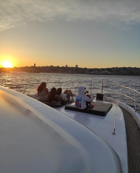 A group of people sitting on a boat deck during sunset. 5