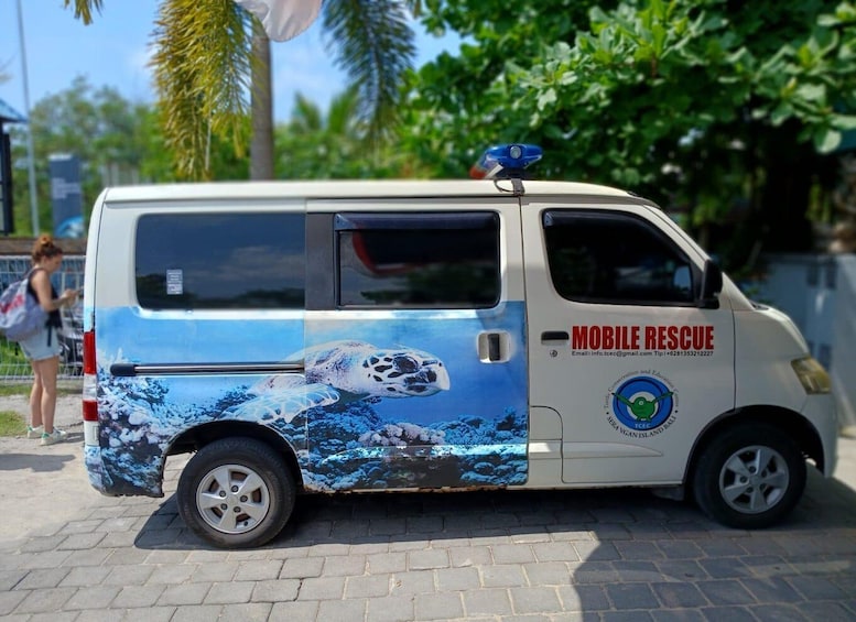 A white van with a blue and white design, labeled "MOBILE RESCUE" and "Turtle Conservation and Education Center," parked on a paved area with greenery in the background. 5