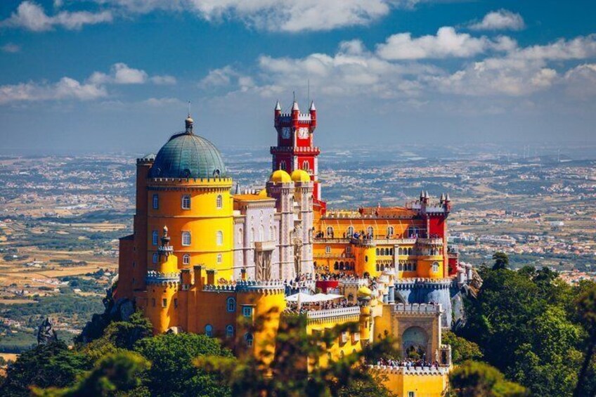 Pena Palace with its distinctive yellow and red architecture, a large dome, and a tower. 1