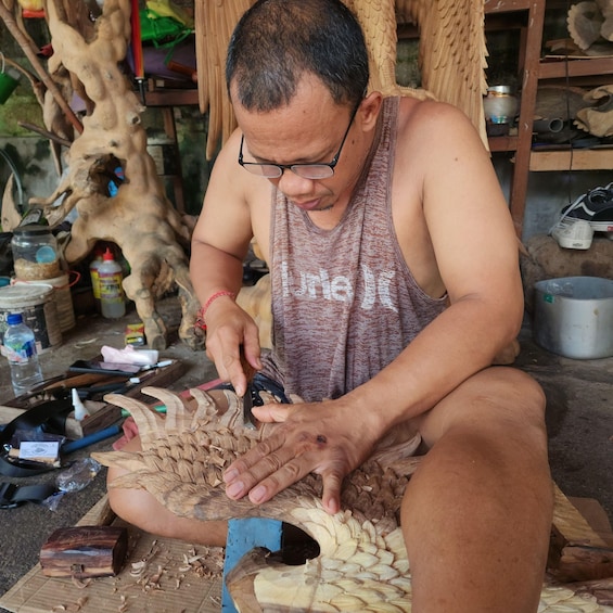 A person carving a wooden sculpture. 4