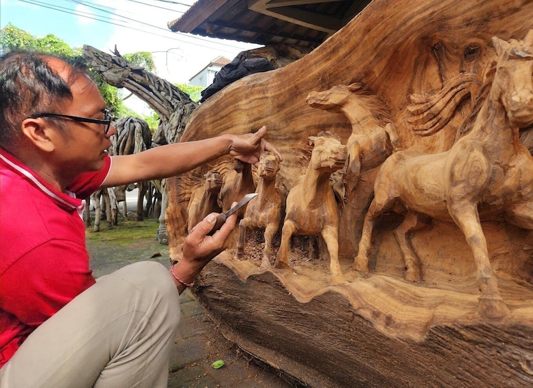 A person carving a wooden sculpture of horses. 3