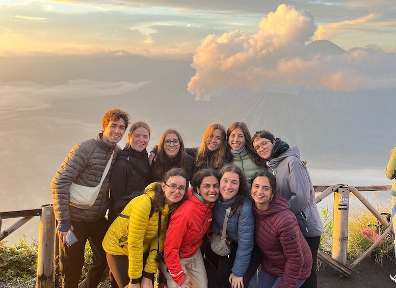 A group of people standing on a wooden platform with a mountainous landscape in the background. 3