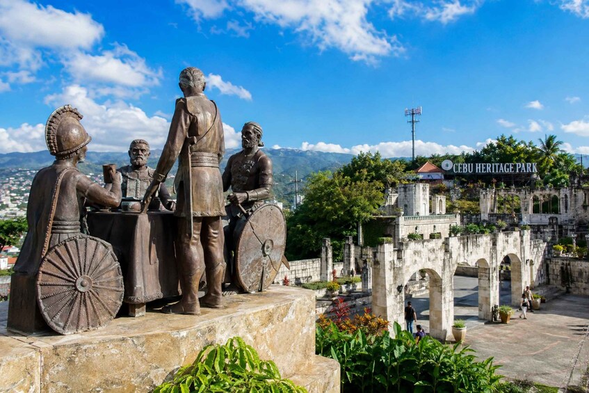 A bronze statue of a historical figure with a horse, set against a backdrop of mountains and a clear sky. 2