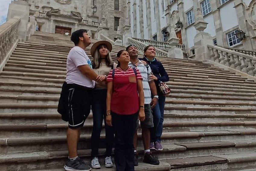 A group of people standing on stone steps in front of a large, ornate building. 4