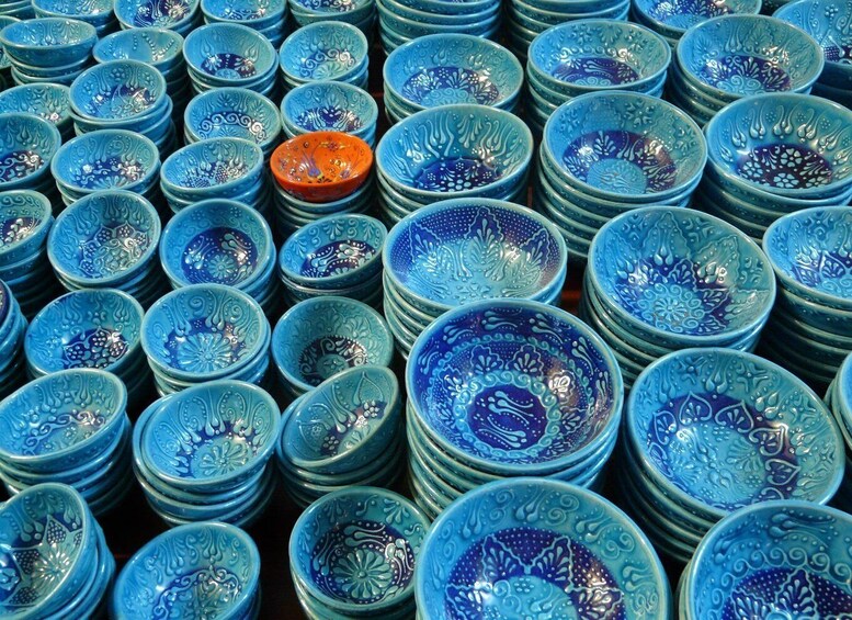 Eine Auswahl kunstvoll gestalteter blauer Schalen, darunter eine einzelne orangene Schale. 2