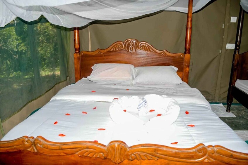 A bed with a canopy, white bedding, and decorative swan pillows. 5