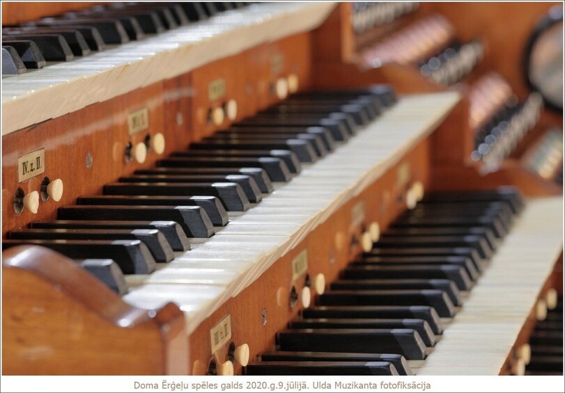 A close-up of a pipe organ with multiple keyboards and pipes. 3