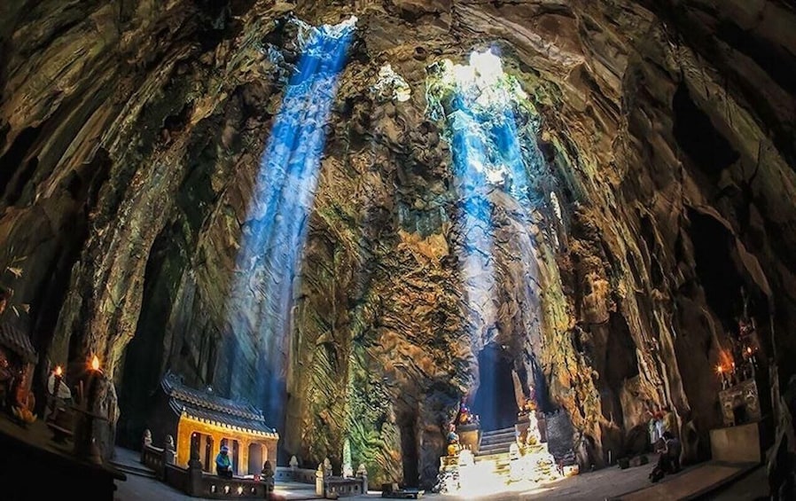 A cave with two waterfalls and a shrine at the bottom. 1
