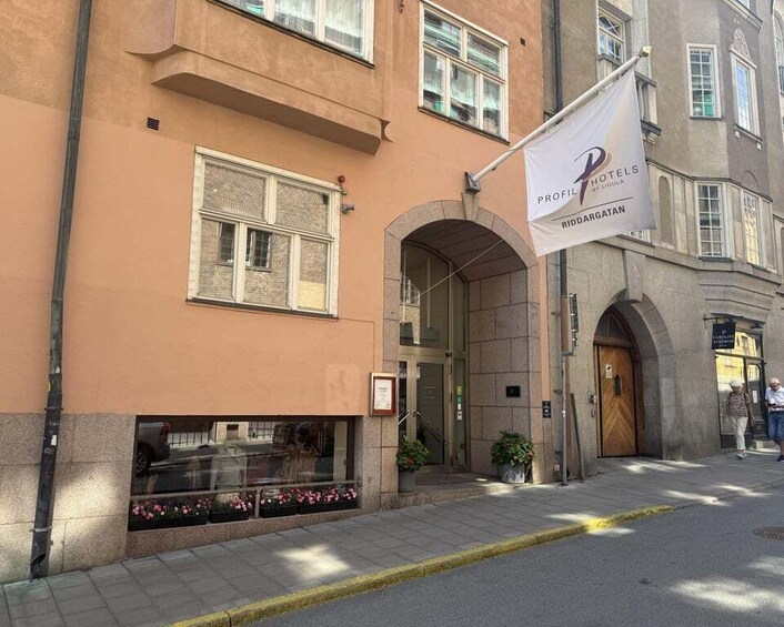 A hotel entrance with a sign reading "PROFILT HOTEL RIDDARGATAN" and a flag. 5