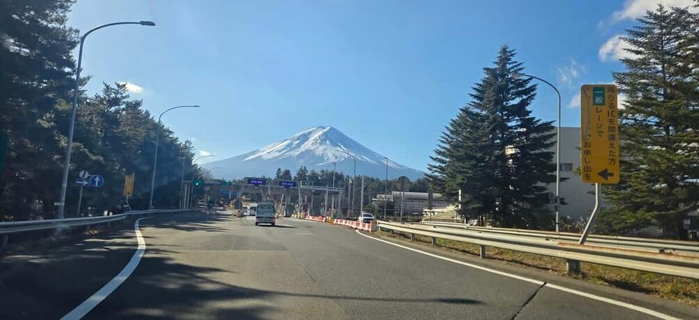 A road with a mountain in the background, traffic signs, and a guardrail. 3