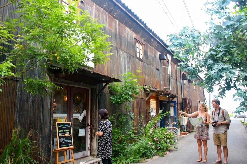 A rustic wooden building with a signboard, surrounded by greenery and a bicycle. 2