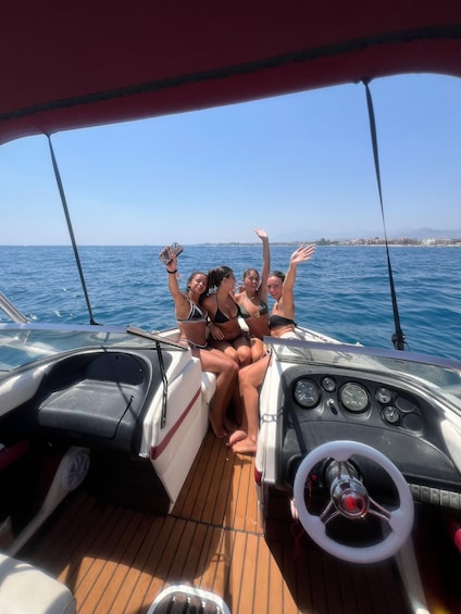 A boat with four people on deck, enjoying the view. 1